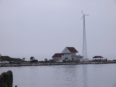 [A shelter and a building near a large-towered windmill.]